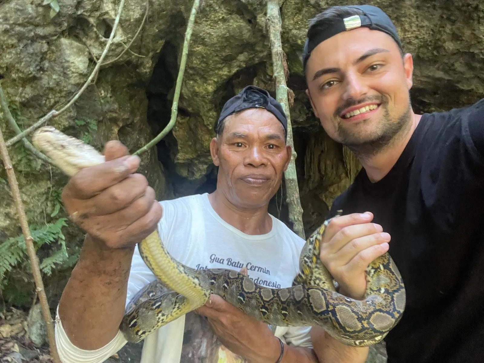 Tourist and guide posing with reticulated python